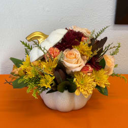 Mixed bouquet in a white pumpkin-shaped vase with peach roses and yellow mums