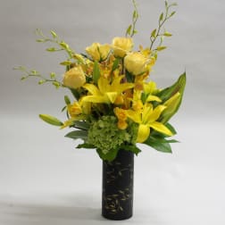 Yellow roses and lilies arranged in a black vase