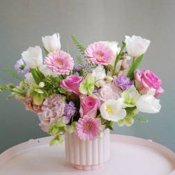 Pink and white mixed flower arrangement in a ribbed vase
