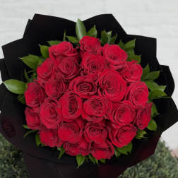 Round bouquet of red roses wrapped in black paper
