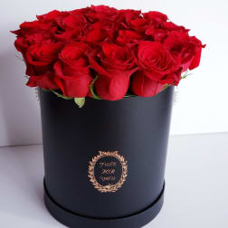 Red roses arranged in a black round box