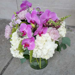 Pink orchids and white hydrangeas in a glass vase