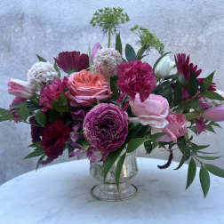 Pink and burgundy mixed flower arrangement in a silver vase