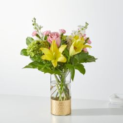 Bouquet of yellow lilies and pink roses in a glass vase