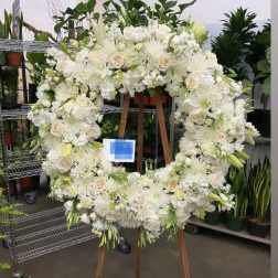 Large white floral wreath on a wooden easel