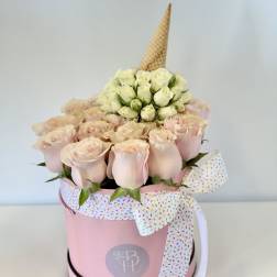 Pink rose arrangement in a round box with a decorative ribbon