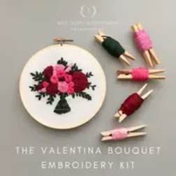 Embroidery kit with a floral bouquet design and small wrapped thread bundles