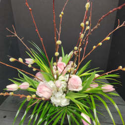 Pink roses and white hydrangea in a low arrangement with tall branches