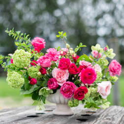 Pink and red rose arrangement in a white vase