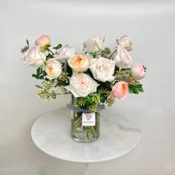 Blush and white roses arranged in a clear glass vase