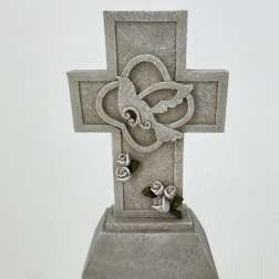 Decorative stone cross with small white roses and green leaves