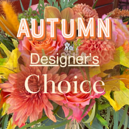 Autumn floral arrangement with orange and pink blooms and yellow leaves