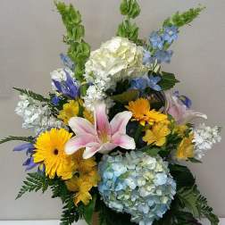 Mixed bouquet in a tall vase with lilies, hydrangeas, and daisies