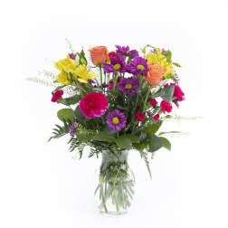 Mixed bouquet of roses, daisies, and carnations in a clear glass vase