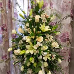 Tall white floral spray with lilies and roses on a stand