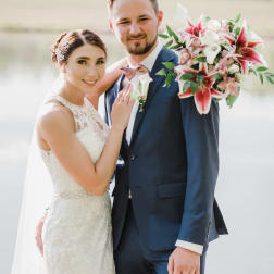 Bride and groom with a pink-and-white wedding bouquet and boutonniere