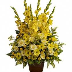 Tall yellow floral arrangement in a brown urn