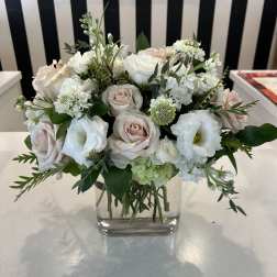 White and blush bouquet in a clear square vase