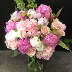 Pink and white bouquet of roses and hydrangeas in a glass vase