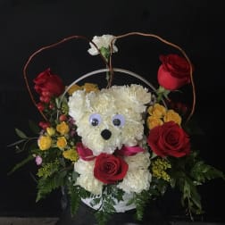 Floral basket with a teddy bear face made of white flowers and red roses