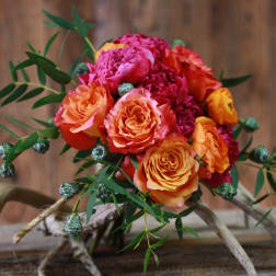 Bouquet of orange and pink roses with greenery