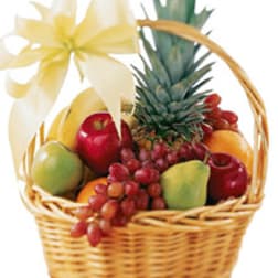 Fruit basket with pineapple, apples, grapes, and a white ribbon bow