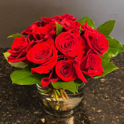 Red roses arranged in a clear glass vase