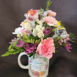 Mixed pink and white flower arrangement with candy pops in a Mom-themed mug.