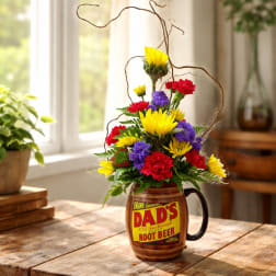 Colorful flower arrangement in a root beer mug vase