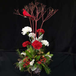 Tall red and white floral arrangement with a red bird topper