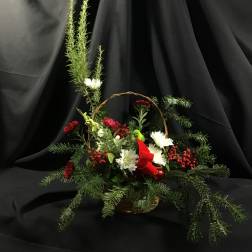 Basket arrangement with white and red flowers and evergreen branches