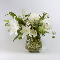 White lilies and chrysanthemums in a clear glass vase