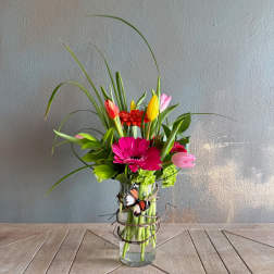 Mixed bouquet with gerbera daisies and tulips in a glass vase