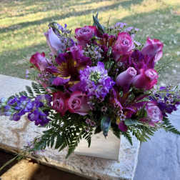 Pink and purple bouquet with roses and mixed blooms in a white box