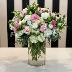 Pink and white roses arranged in a clear glass vase