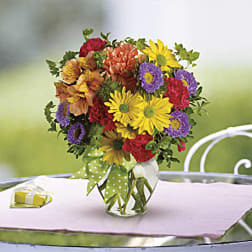 Colorful bouquet of daisies and alstroemeria in a glass vase