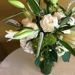 White roses and lilies arranged in a glass vase