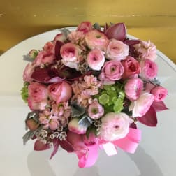 Pink and burgundy bouquet with a ribbon on a white table