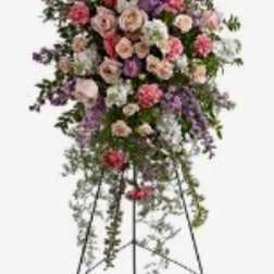 Standing floral spray with pink, purple, and white blooms on an easel