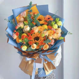 Large bouquet of orange and peach roses with sunflowers and gerbera daisies