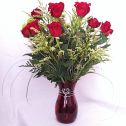 Red roses arranged in a burgundy glass vase