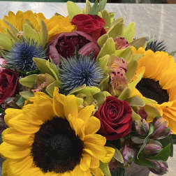 Bouquet with sunflowers, red roses, and blue thistle