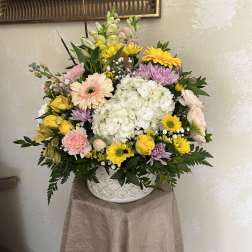 Mixed pastel flower arrangement in a white ceramic vase