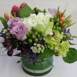 Mixed bouquet with lavender roses, white hydrangea, and green orchids in a vase