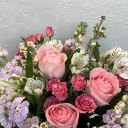 Pink roses with lavender and white mixed flowers in a bouquet