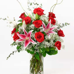 Red roses and pink lilies in a clear glass vase