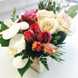 Mixed bouquet with roses, tulips, and white calla lilies in a wooden box