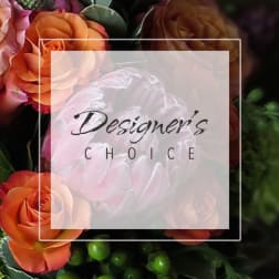 Orange roses with a pale pink flower in the center and a "Designer’s Choice" label