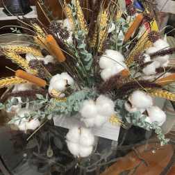 Arrangement of cotton bolls, wheat, and dried grasses in a container