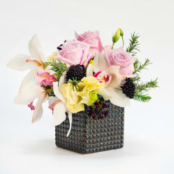 Pink roses and white orchids in a textured square vase
